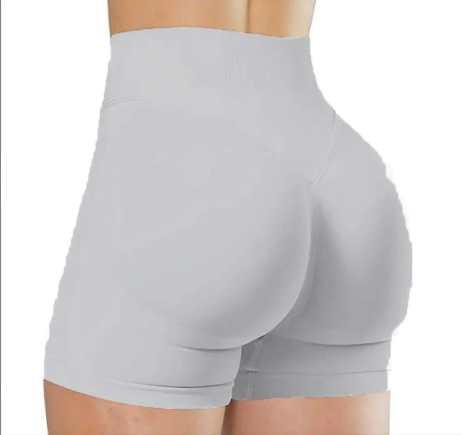 A close-up view of light gray high-waisted yoga shorts worn by a person.