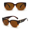 Brown-tinted sunglasses with dark brown frames and gold accents viewed from above.