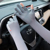 A hand wearing a light gray UV protection arm sleeve is visible inside a car, near the steering wheel.