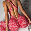 A woman wearing a red leopard print seamless yoga jumpsuit, shown from the back.