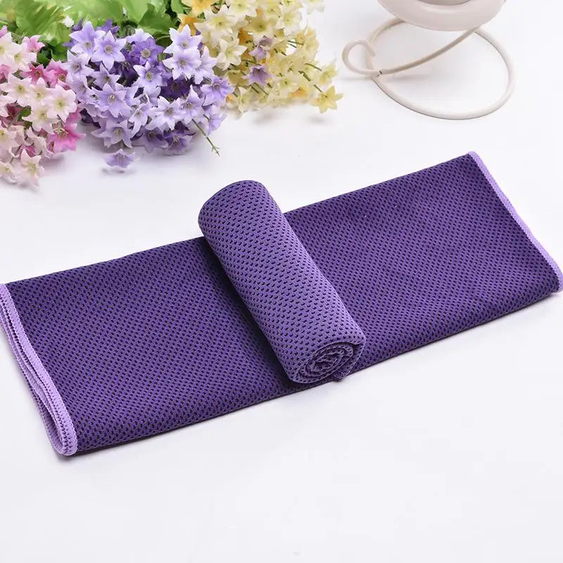 Serviette de refroidissement circulaire violette roulée sur une surface blanche avec des fleurs de couleur claire en arrière-