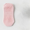 Chaussette de yoga et de fitness rose respirante avec une semelle texturée et bullée.