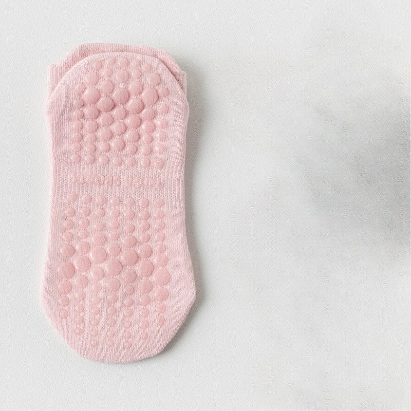 Chaussette de yoga et de fitness rose respirante avec une semelle texturée et bullée.