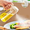 A hand sprays golden olive oil onto food with a glass oil sprayer.