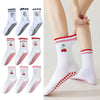 Un ensemble de chaussettes de yoga blanches avec broderies rouges et antidérapantes, présentées dans divers styles.