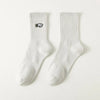 A pair of white men's athletic crew socks with a black embroidered logo on the calf.
