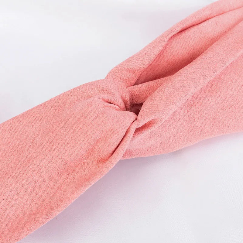 A soft coral pink bohemian chiffon headband tied in a knot, shown from the side.