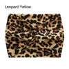 A close-up of a black and tan leopard print fabric tied into a cross knot for a headband.
