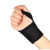 A hand is gripping a black wrist support brace for pain relief.