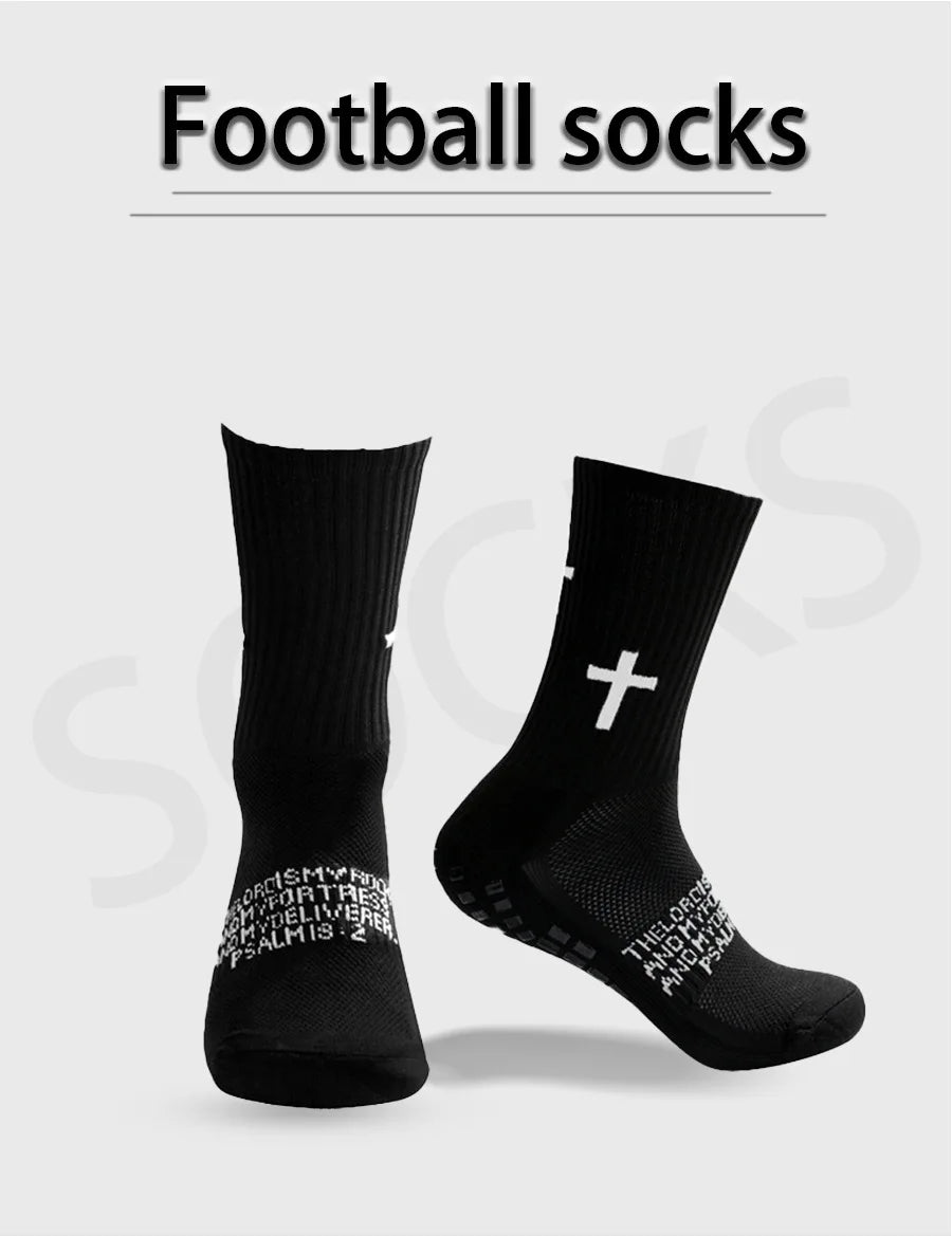 Un par de calcetines de fútbol negros con un diseño de cruz blanca, mostrados sobre un fondo gris claro.