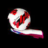 A close-up of a white soccer ball with red markings resting on a pair of pink and black goalkeeper gloves.