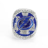 A close-up of a brilliant silver ring set with blue gemstones featuring a lightning bolt design.