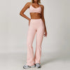 A woman wearing a light pink three-piece yoga sports set consisting of a cropped top and full-length pants.