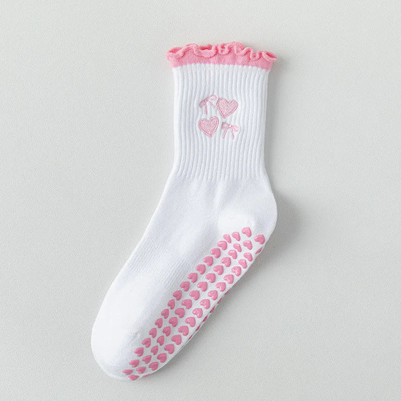 Chaussettes de yoga blanches avec broderies roses de cœurs et un motif de préhension rose