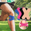 A close-up of a person's knee showing various colors of kinesiology tape applied for joint support.