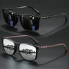 A pair of vintage square sunglasses with dark lenses and brown frames resting on a dark surface.