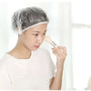 Una mujer está aplicando gorros de ducha desechables transparentes en su cabello para extensiones o trenzas.