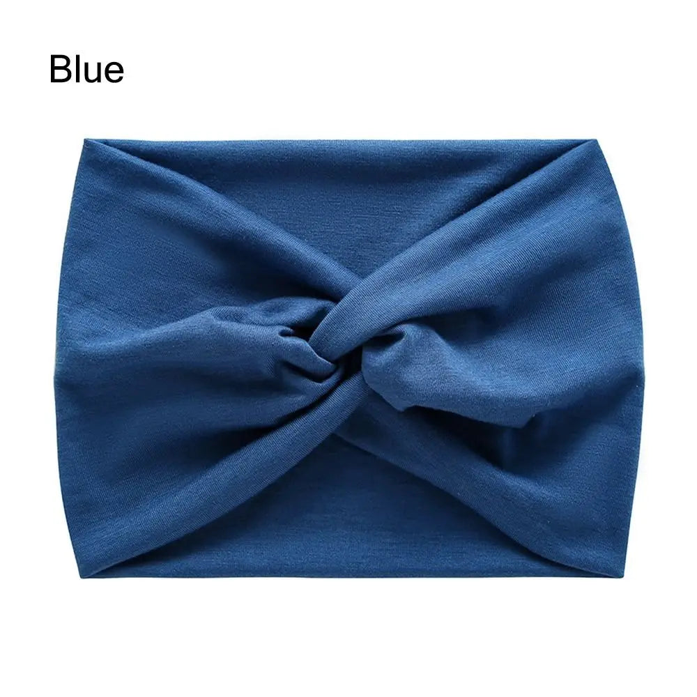 A royal blue fabric headband is shown folded in a cross-knotted style.