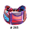 A colorful boho cotton turban headband featuring abstract patterns in purple, pink, blue, and red.