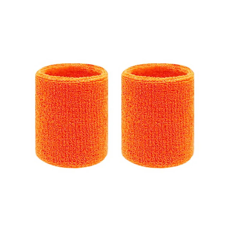 A pair of bright orange dual sports wristbands for sweat absorption.