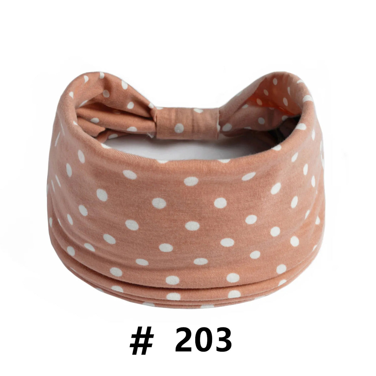 A beige knitted headband with white polka dots tied in a bow.