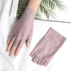 A pair of mauve thin stretch elastane gloves shown on a hand, resting on a white surface.