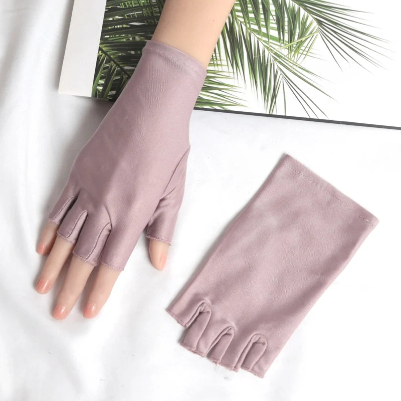 A pair of mauve thin stretch elastane gloves shown on a hand, resting on a white surface.
