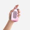 A hand is holding a pink cooling towel with a mesh texture and a lanyard.