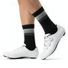 A pair of white cycling shoes and black socks with gray stripes are shown on a white background.