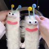 Pair of white knit socks shaped like cartoon faces with yellow and blue pom-poms on the ears