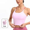 A woman models a pink summer strappy yoga sports bra with built-in padding.