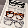 A display of five pairs of square anti-blue light eyewear in various frames and colors.