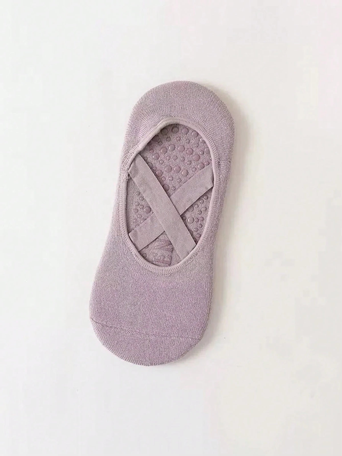 Un par de calcetines de fitness de silicona malva antideslizantes, diseñados para yoga y pilates.
