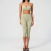 A woman models a light olive green women's premium fitness tracksuit consisting of a sports bra top and leggings.