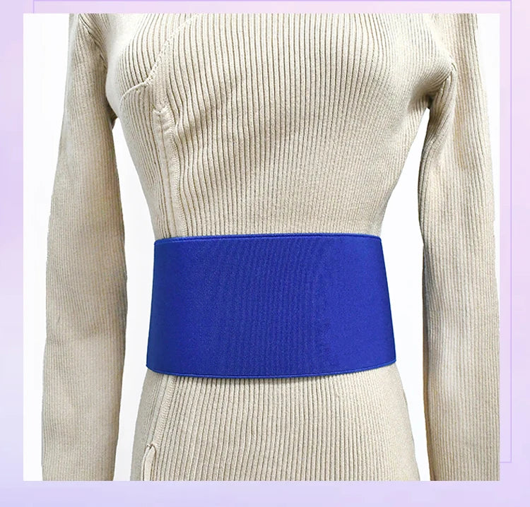 A close-up of a royal blue elastic band worn around the waist of a beige knitted garment.