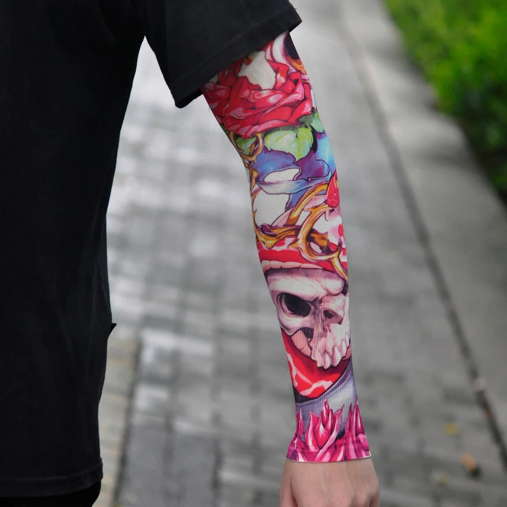 Close-up of a person's arm displaying colorful floral and skull tattoo sleeves for sun protection
