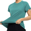 A woman wearing a teal quick dry moisture-wicking gym t-shirt and black pants.