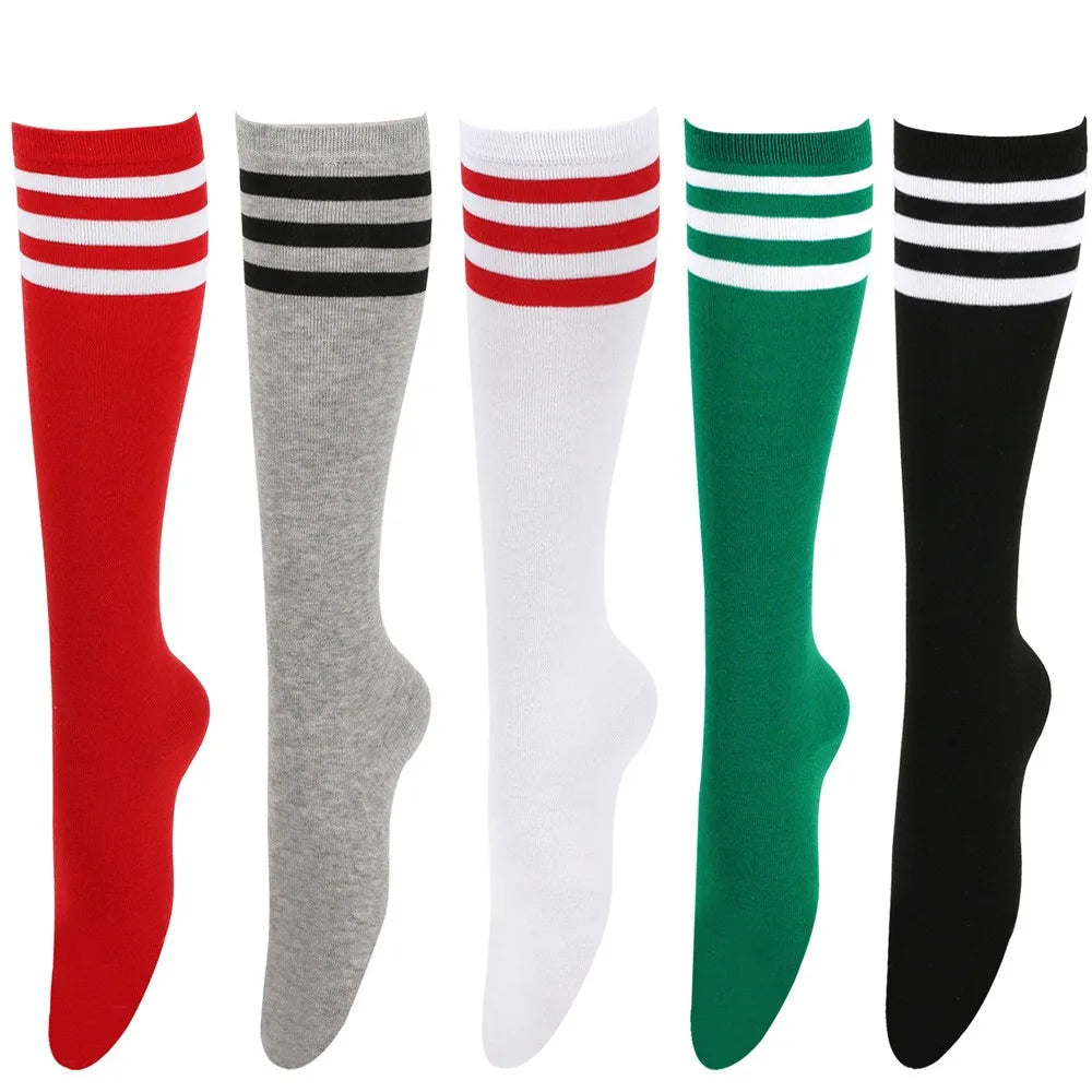 Un set de cinco medias de cuello alto a la pierna rayadas en rojo, gris, blanco, verde y negro.