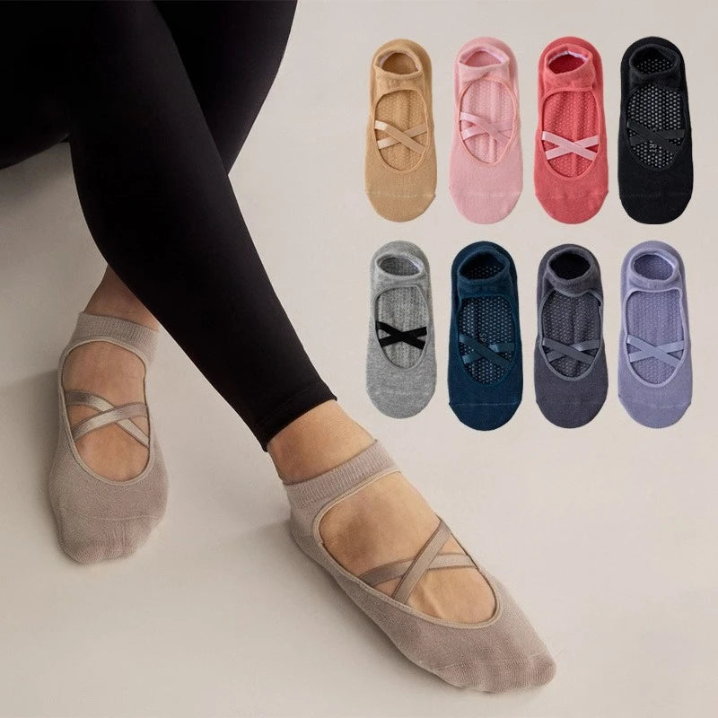 A collection of pink, beige, and gray crisscross strap yoga socks displayed on a person's foot.
