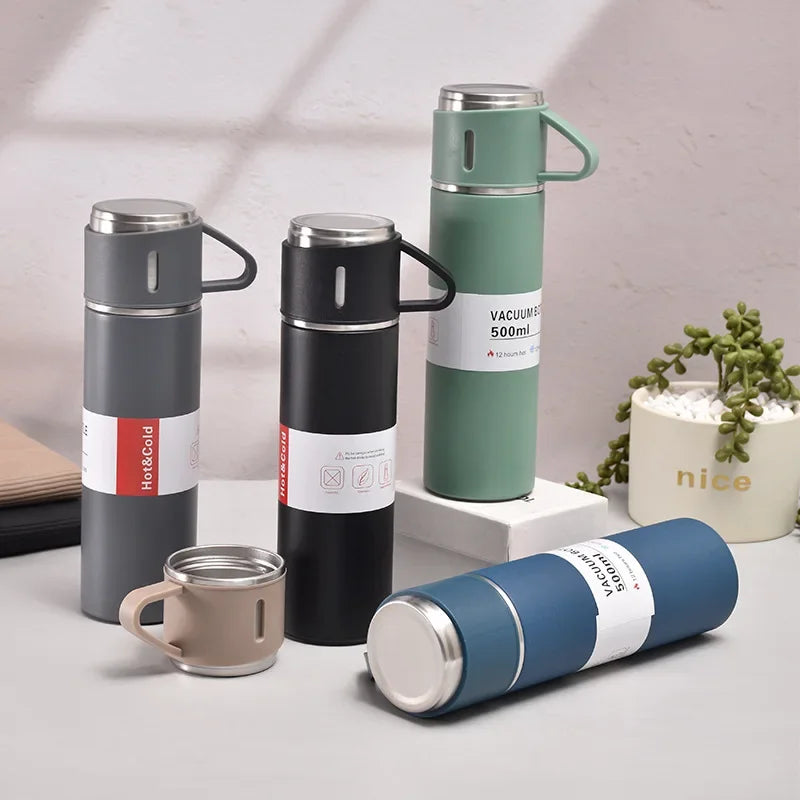 A collection of stainless steel vacuum flasks in various colors and sizes, including a tall green flask and a smaller beige c