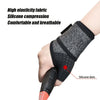 A hand is wearing a black silicone compression wristband on the wrist, highlighting the silicone dots.