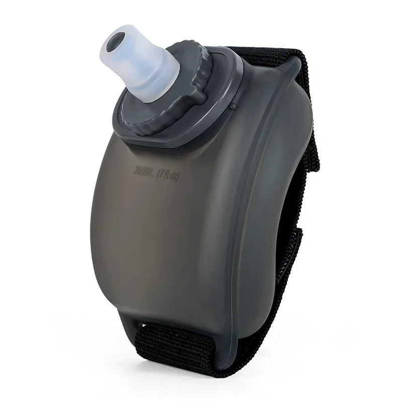 A gray durable sports wrist water bottle with a clear mouthpiece and black strap.