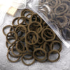 A pile of 50 pieces of mixed color elastic hair bands in a clear plastic bag on a gray surface.
