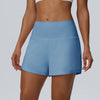 Eine Frau trägt hellblaue Damen-Sportshorts aus schnelltrocknendem Material.