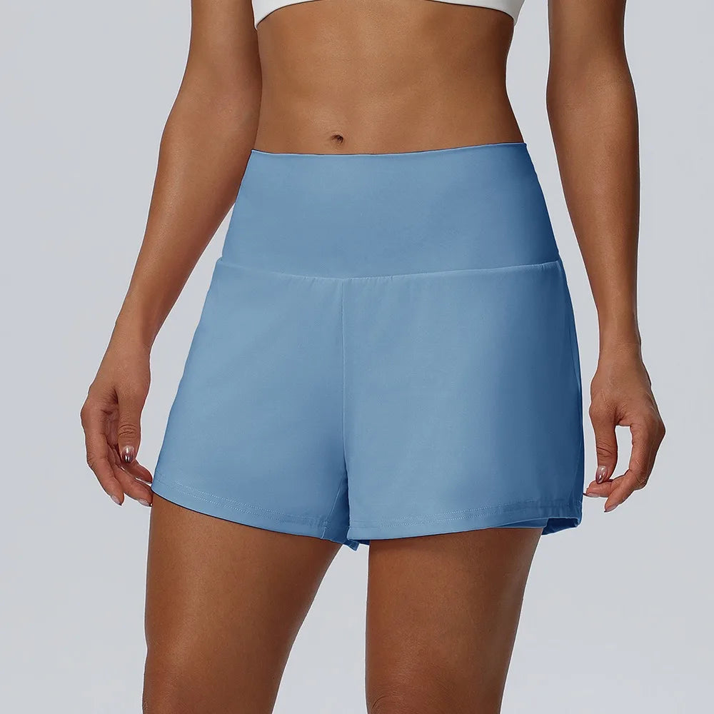 Eine Frau trägt hellblaue Damen-Sportshorts aus schnelltrocknendem Material.