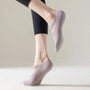 Primer plano de un par de calcetines de yoga y pilates cómodos color malva puestos en el pie de una persona.