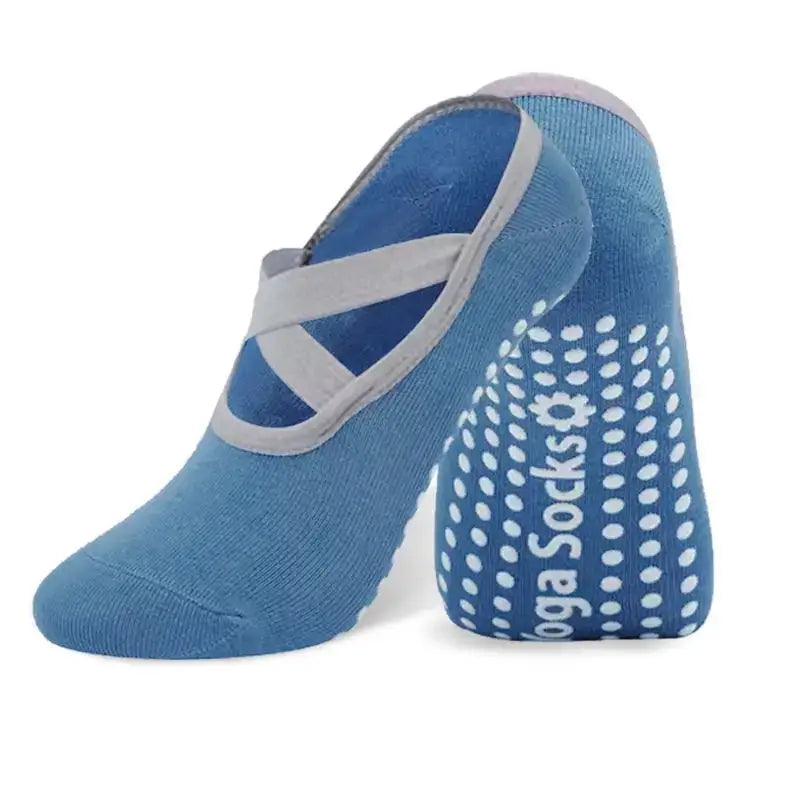 A pair of blue silicone anti-slip pilates and yoga socks with a grey strap and dotted pattern.