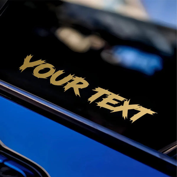 Close-up of a dark screen displaying the text YOUR TEXT, likely a custom decal on a vehicle.