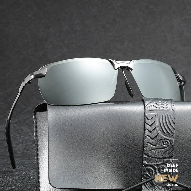 Gafas polarizadas foto-cromáticas plateadas descansando sobre una funda de cuero gris oscuro.