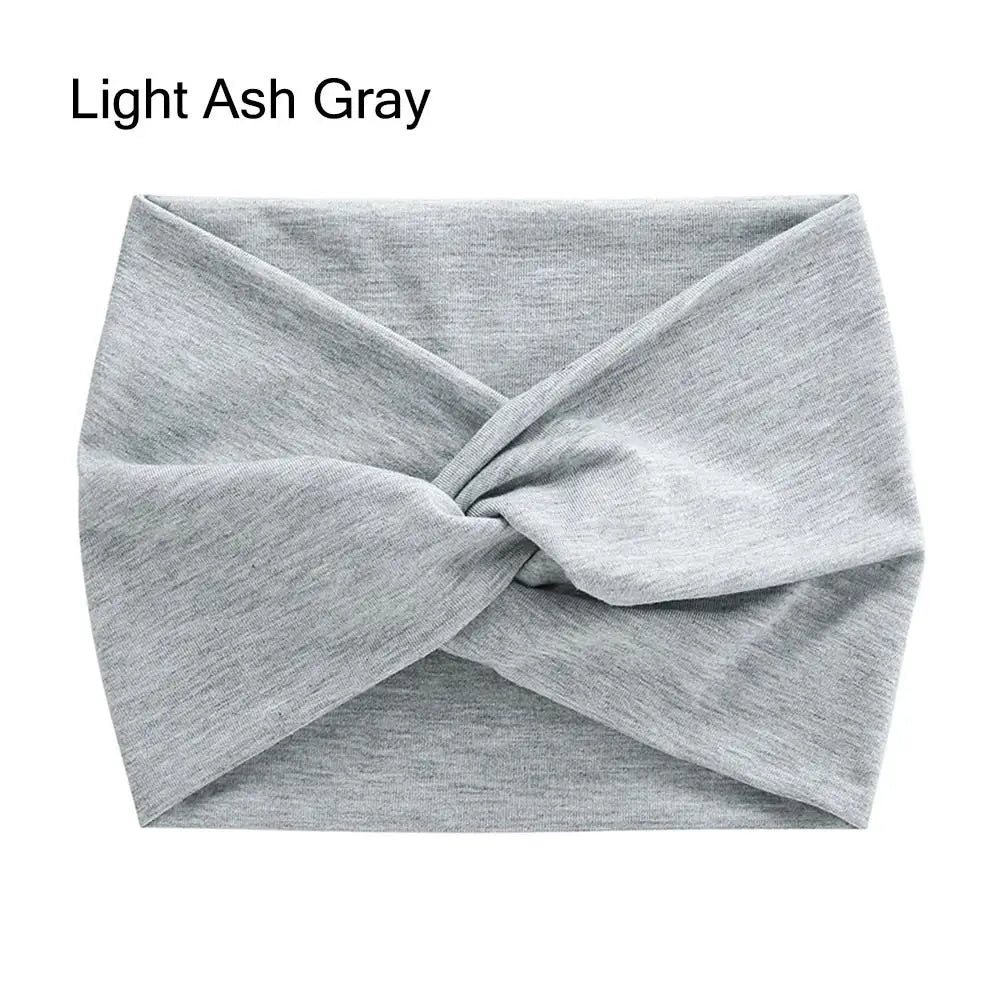A light ash gray fabric headband is shown folded in a cross-knotted style.